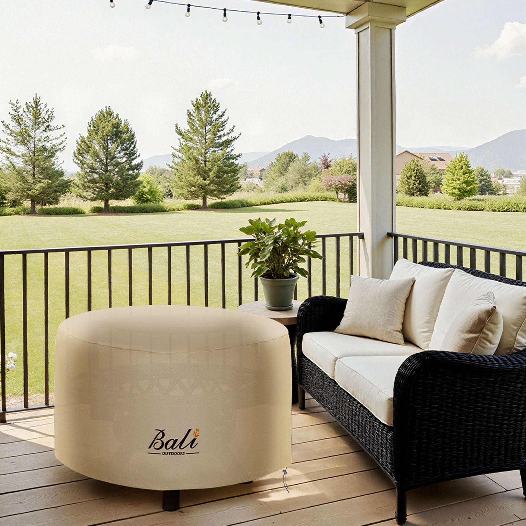 48 inch round brown Bali Outdoors fire pit cover on a deck with a sofa.
