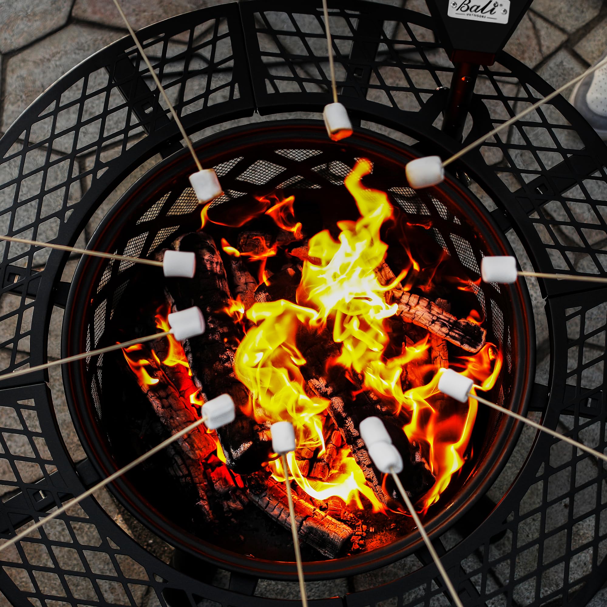 Black 32 inch wood fire pit with diamond lattice roasting marshmallows over bright flames.
