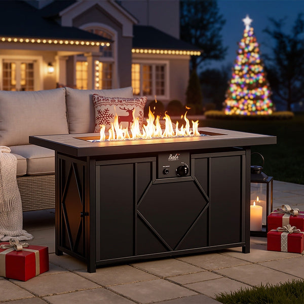 A festive patio scene with a lit fire pit table, Christmas tree, lights, and gifts creating a warm holiday ambiance